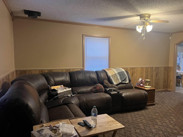 living room featuring a textured ceiling, ceiling fan, and ornamental molding