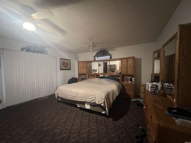 carpeted bedroom featuring ceiling fan and a textured ceiling