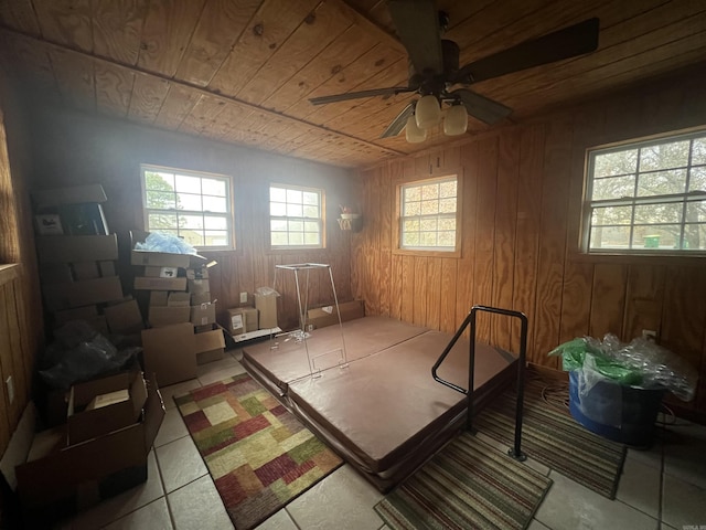 miscellaneous room with ceiling fan, wood walls, wood ceiling, and light tile patterned flooring