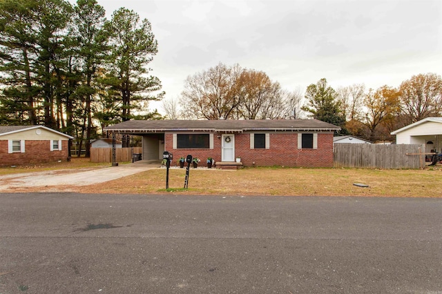 ranch-style home featuring a front lawn and a carport