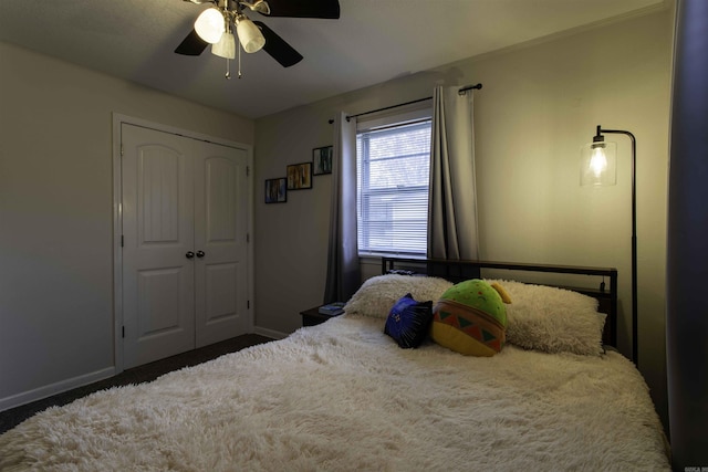 bedroom featuring ceiling fan, dark carpet, and a closet