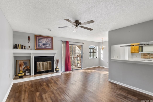 unfurnished living room featuring dark hardwood / wood-style floors, a textured ceiling, and ceiling fan with notable chandelier