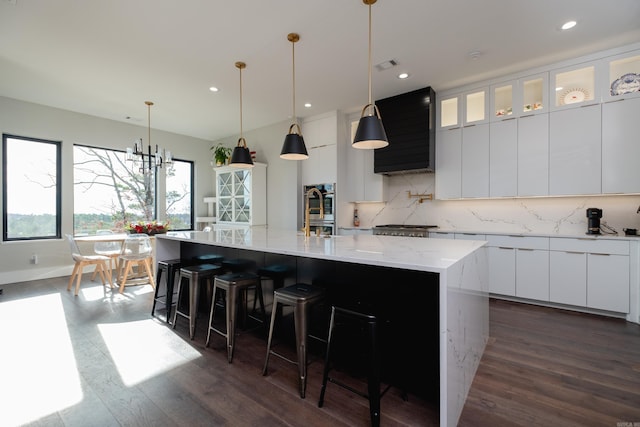 kitchen featuring dark hardwood / wood-style flooring, a spacious island, white cabinetry, and decorative backsplash