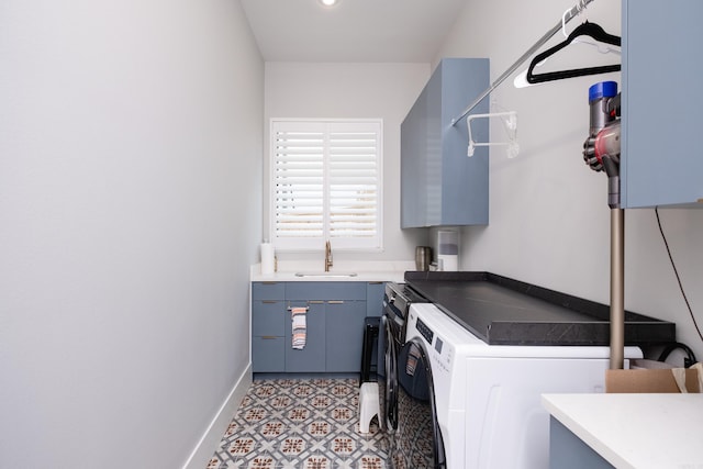 laundry room with washing machine and clothes dryer, sink, and cabinets