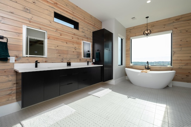 bathroom featuring vanity, wooden walls, and a tub