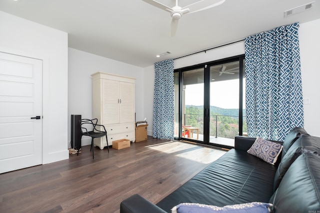 living room featuring ceiling fan and dark wood-type flooring