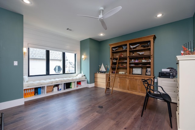 home office with dark hardwood / wood-style floors, ceiling fan, and wood walls