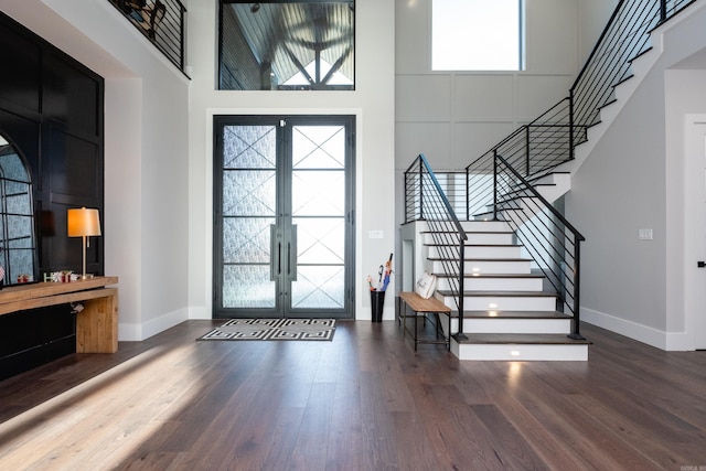 entrance foyer with french doors, dark wood-type flooring, and a high ceiling