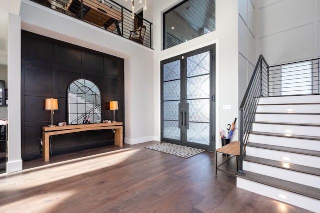 entryway with a high ceiling, french doors, and wood-type flooring