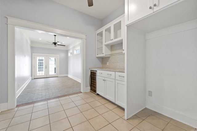 kitchen featuring french doors, light tile patterned floors, tasteful backsplash, wine cooler, and white cabinets