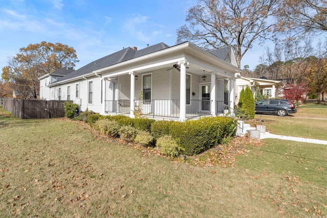 view of side of home featuring a porch and a lawn