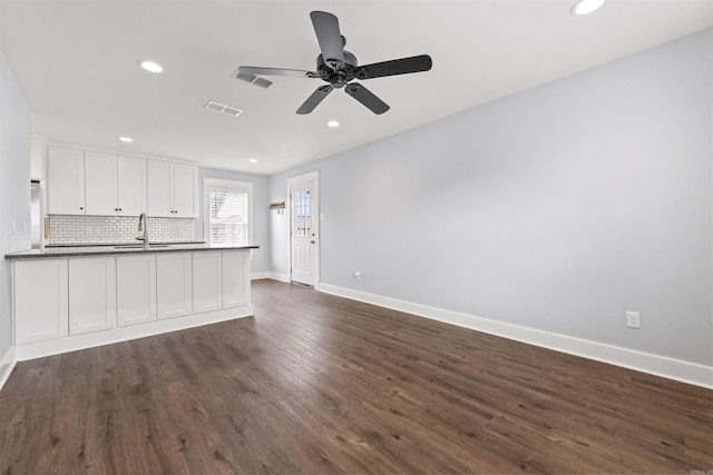 kitchen featuring backsplash, white cabinets, sink, dark hardwood / wood-style floors, and ceiling fan