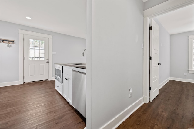 kitchen with dark hardwood / wood-style floors, sink, white cabinetry, and stainless steel appliances