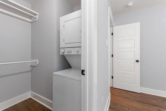 clothes washing area featuring dark hardwood / wood-style flooring and stacked washer and dryer