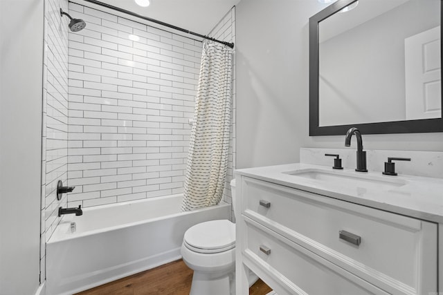 full bathroom with hardwood / wood-style floors, vanity, shower / bath combination with curtain, and toilet