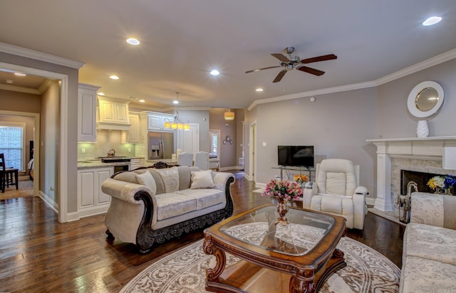 living room featuring dark hardwood / wood-style floors, ceiling fan, and crown molding