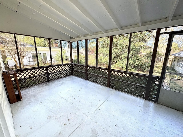 unfurnished sunroom with vaulted ceiling with beams and a wealth of natural light