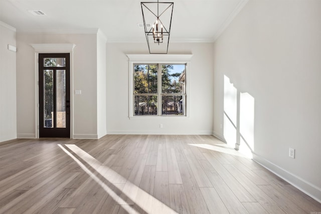 entrance foyer featuring hardwood / wood-style flooring, ornamental molding, and an inviting chandelier