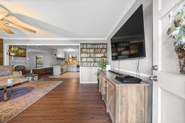 living room featuring ceiling fan, dark wood-type flooring, a textured ceiling, and ornamental molding