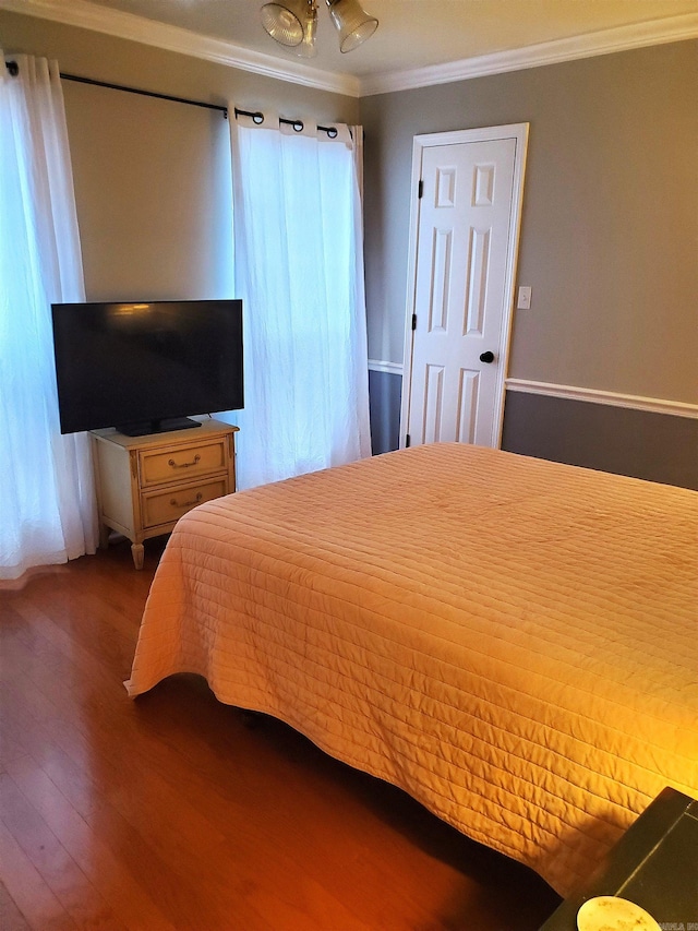 bedroom with ceiling fan, crown molding, and dark wood-type flooring