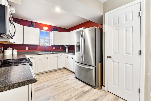 kitchen with white cabinets, light wood-type flooring, sink, and appliances with stainless steel finishes