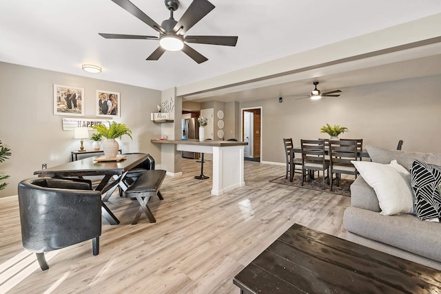 living room featuring ceiling fan and light hardwood / wood-style flooring