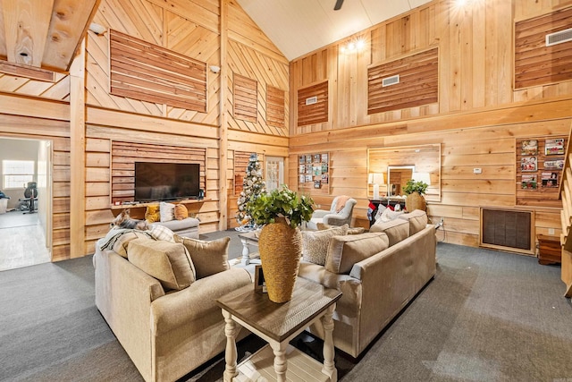 carpeted living room featuring high vaulted ceiling and wood walls