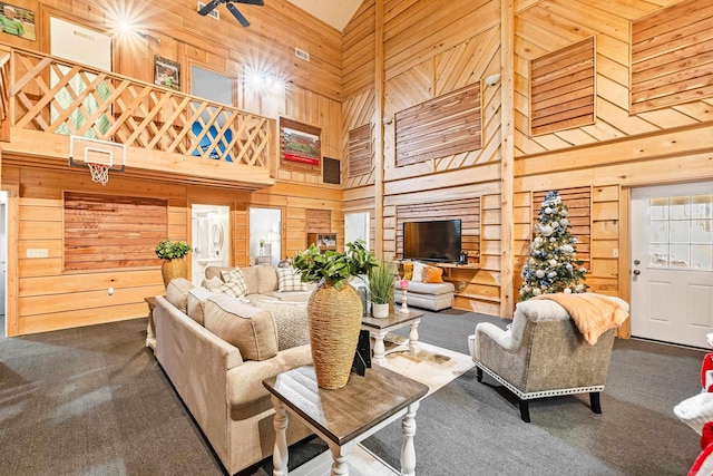 carpeted living room with wood walls and high vaulted ceiling