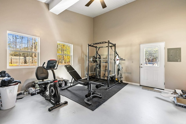 exercise area featuring a high ceiling, electric panel, and ceiling fan