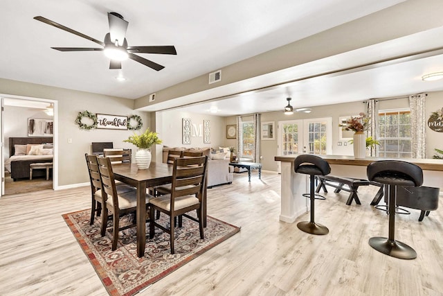 dining room with ceiling fan, french doors, and light hardwood / wood-style flooring