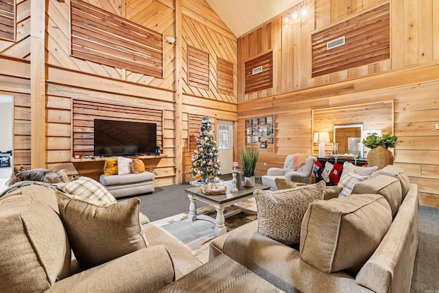 carpeted living room featuring wooden walls, high vaulted ceiling, and wood ceiling