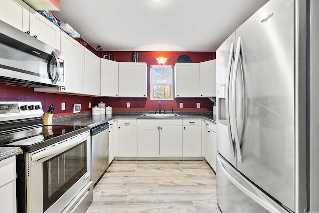 kitchen featuring white cabinets, light wood-type flooring, stainless steel appliances, and sink