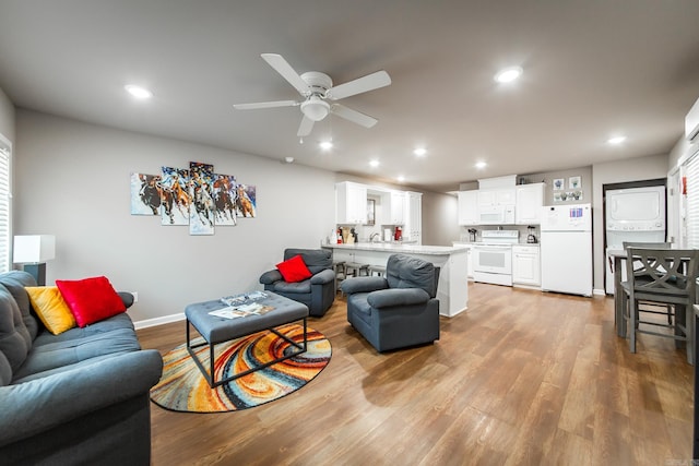 living room featuring ceiling fan and light hardwood / wood-style flooring