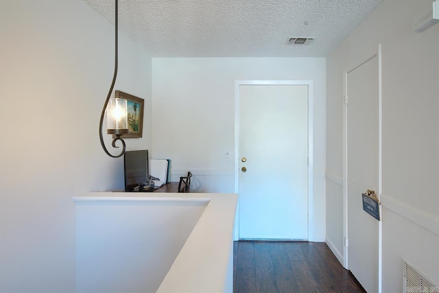 hallway with dark hardwood / wood-style flooring and a textured ceiling