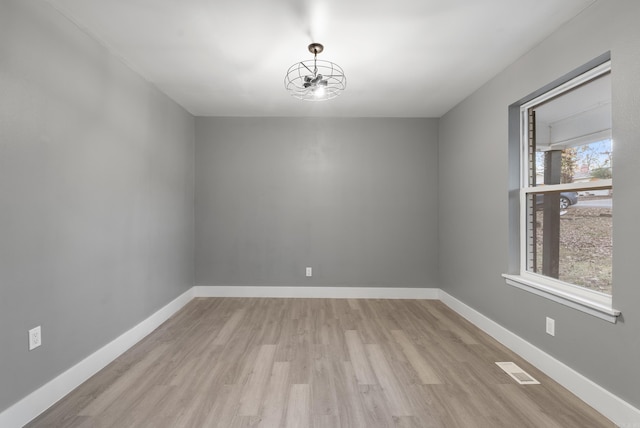 spare room featuring plenty of natural light and light hardwood / wood-style flooring