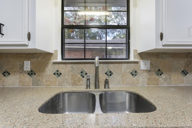 kitchen featuring decorative backsplash, sink, white cabinets, and light stone counters