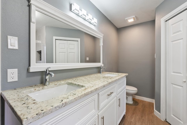 bathroom with hardwood / wood-style floors, vanity, and toilet