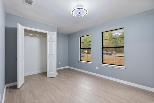 unfurnished bedroom with a closet and light hardwood / wood-style floors