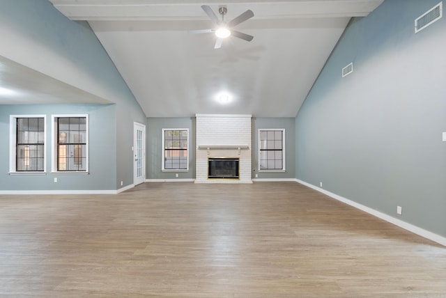 unfurnished living room with high vaulted ceiling, light hardwood / wood-style flooring, ceiling fan, a fireplace, and beamed ceiling