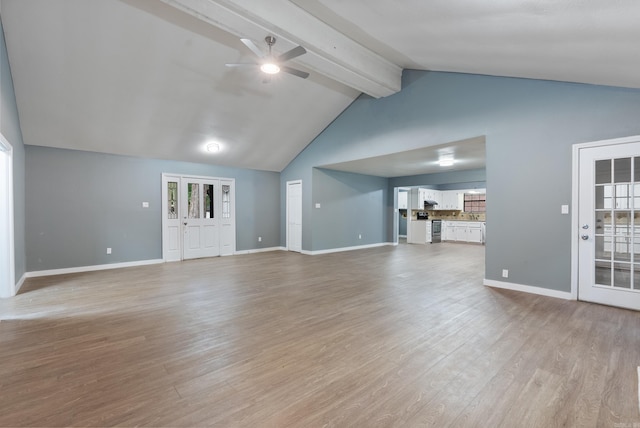 unfurnished living room featuring ceiling fan, lofted ceiling with beams, and light wood-type flooring