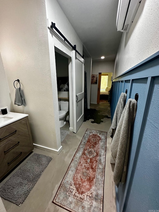 bathroom with vanity, toilet, and concrete floors