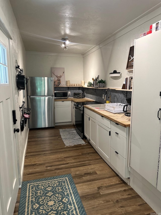 kitchen featuring wooden counters, stainless steel appliances, sink, dark hardwood / wood-style floors, and white cabinetry