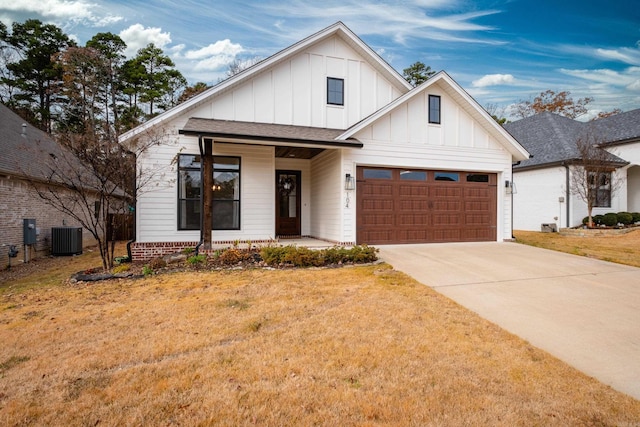 view of front facade featuring a front yard, central AC, a garage, and covered porch