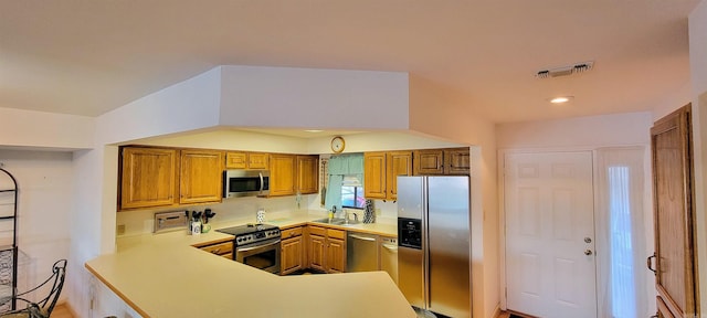 kitchen featuring kitchen peninsula, sink, and appliances with stainless steel finishes