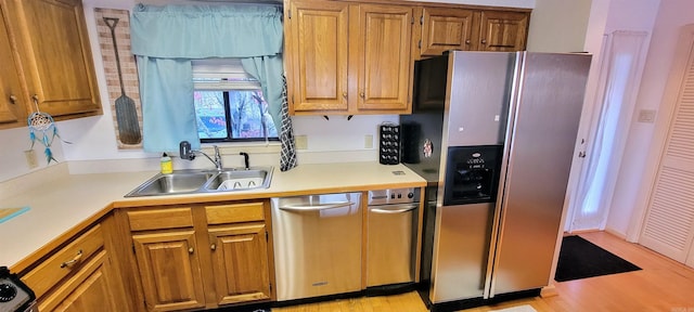 kitchen with sink, light wood-type flooring, and stainless steel appliances