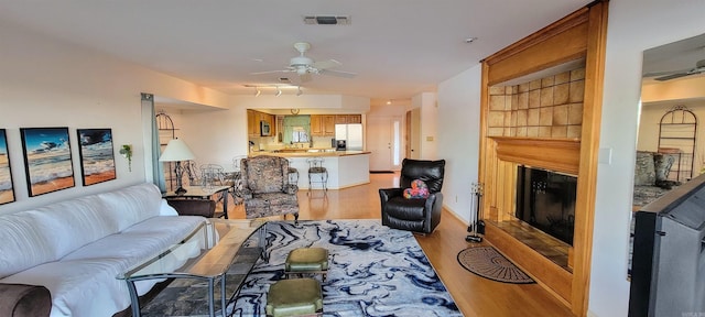 living room with ceiling fan and light wood-type flooring