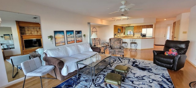 living room with ceiling fan and light hardwood / wood-style floors