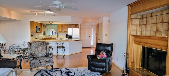 living room with rail lighting, ceiling fan, light hardwood / wood-style floors, and sink