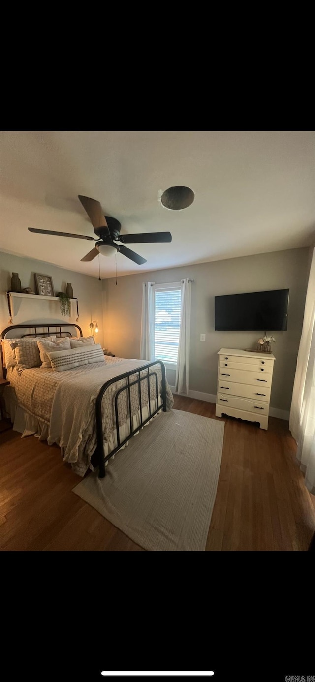 bedroom with dark hardwood / wood-style flooring and ceiling fan