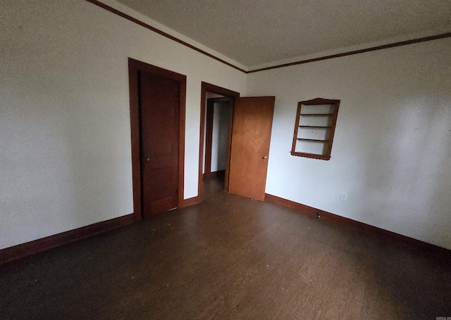 empty room featuring dark hardwood / wood-style floors and ornamental molding